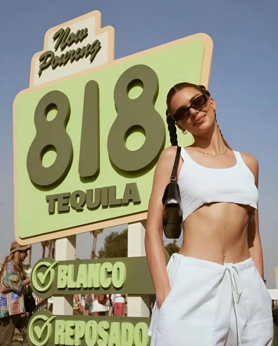Kendall Jenner posing in front of a custom fabricated 818 Tequila sign for Revolve Festival.