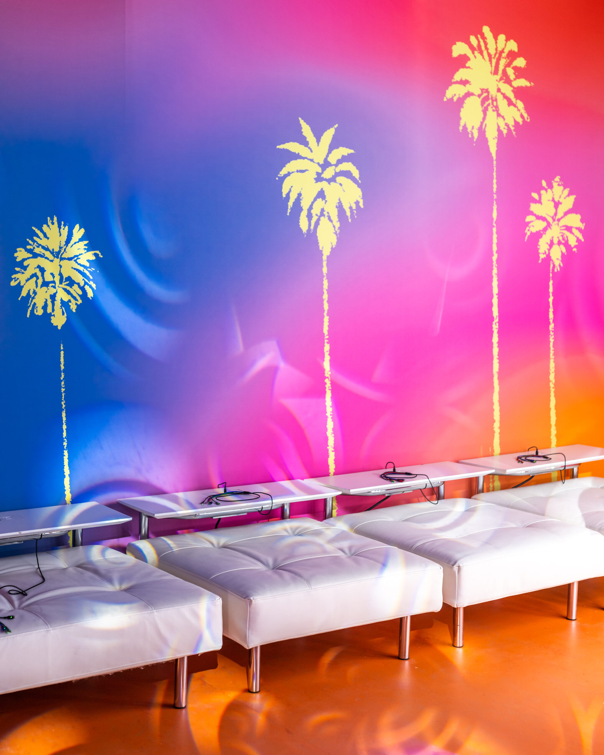 Lounge seating with a colorful gradient backdrop.