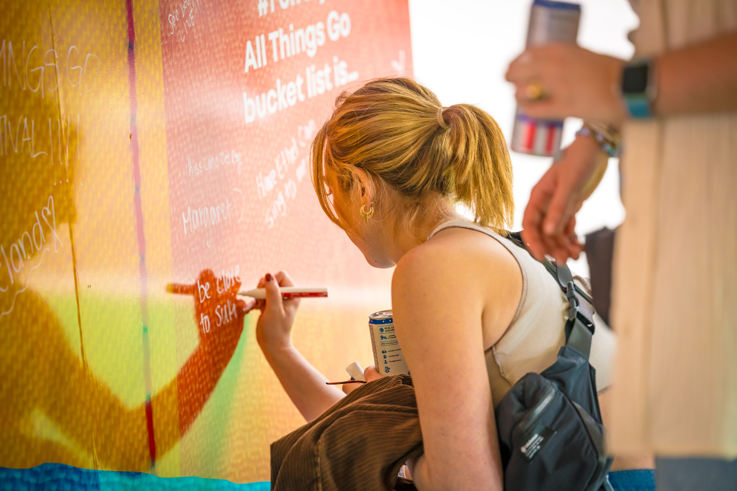 A guest writing on a giant interactive mural.