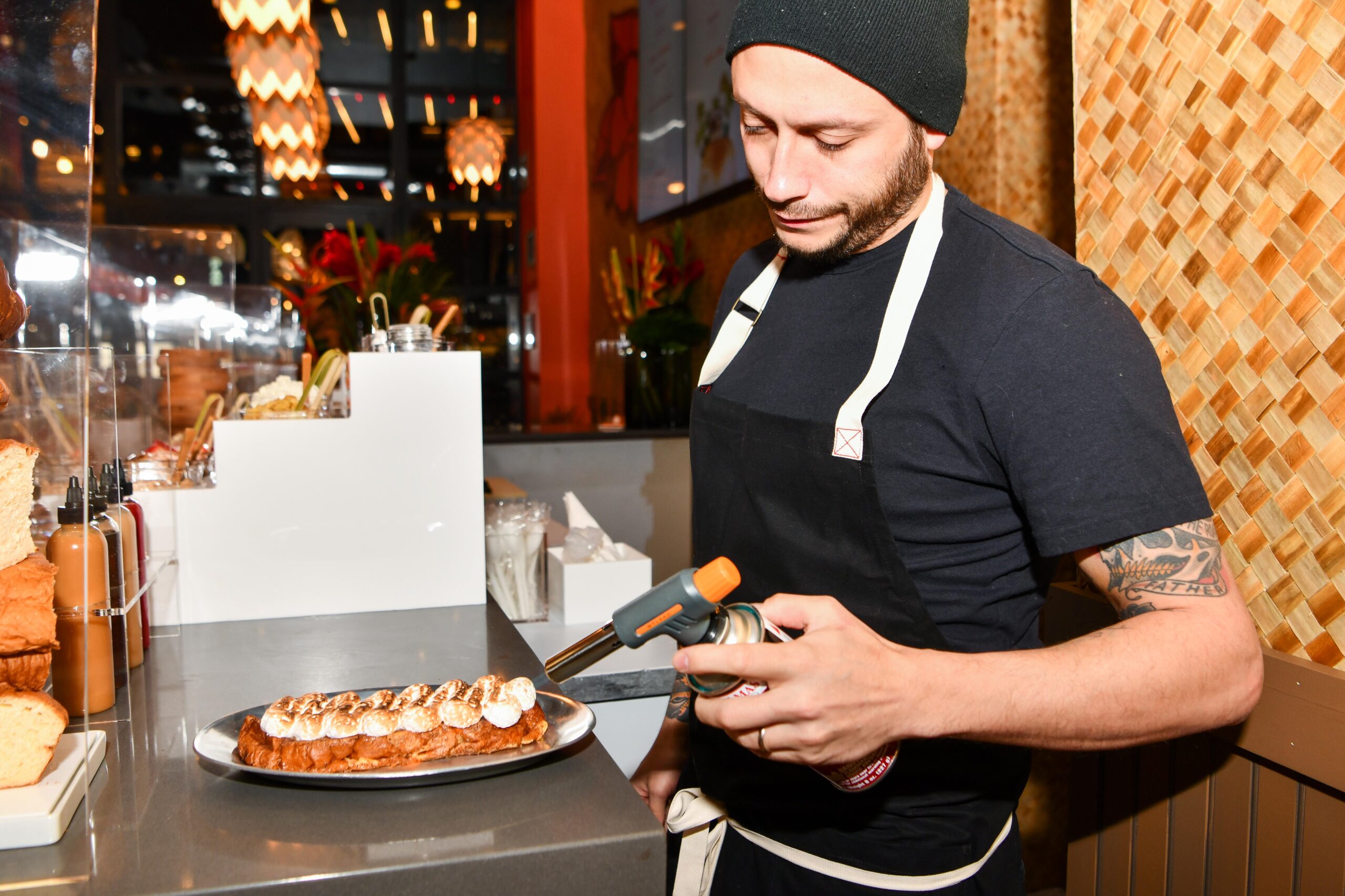 A chef blow-torching meringue for a dish.